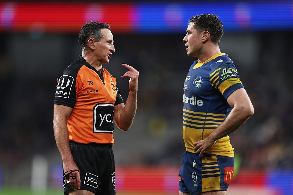 An NRL referee gestures as he explains a decision to a Parramatta Eels player during a match