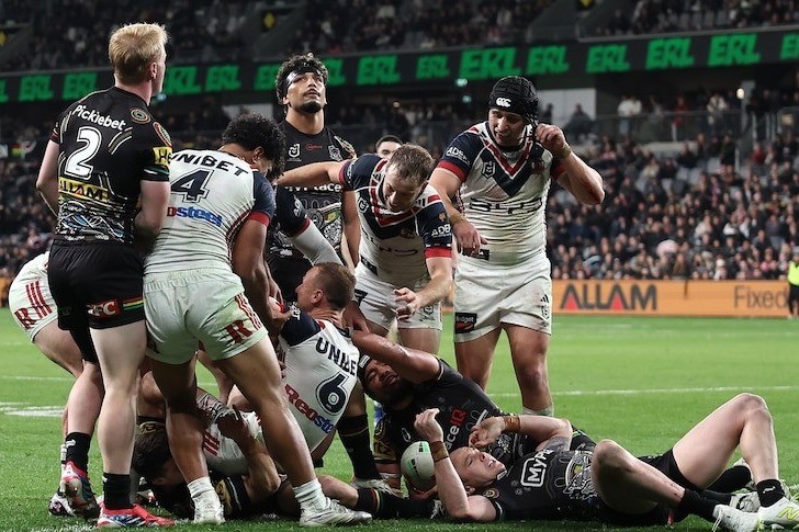 Roosters and Penrith players contest the ball on the ground during an NRL match