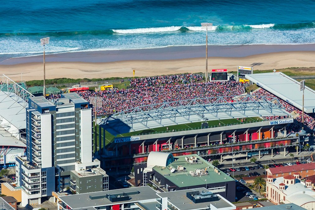 WIN Stadium from the air in Wollongong, the crowded ground sitting immediately behind the beach and breaking surf