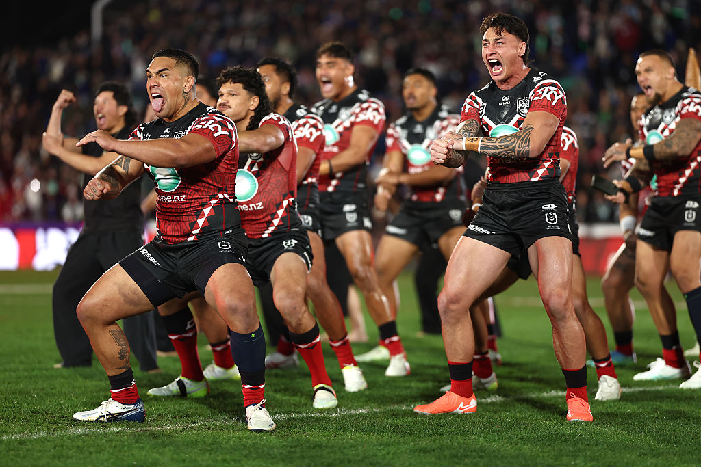 Two Canberra Raiders players embrace in celebration during an NRL match